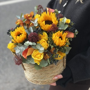 Композиция в сумке "Тональность" из подсолнухов, калл, ягод вибирнума, лимонных роз, скиммии и орхидеи в Рузе