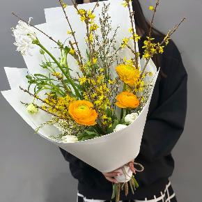 Весенний букет с желтыми ранункулюсами и цветущими ветками форзиции в Рузе